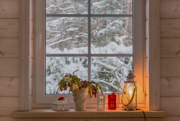 Snowy window with lantern in front