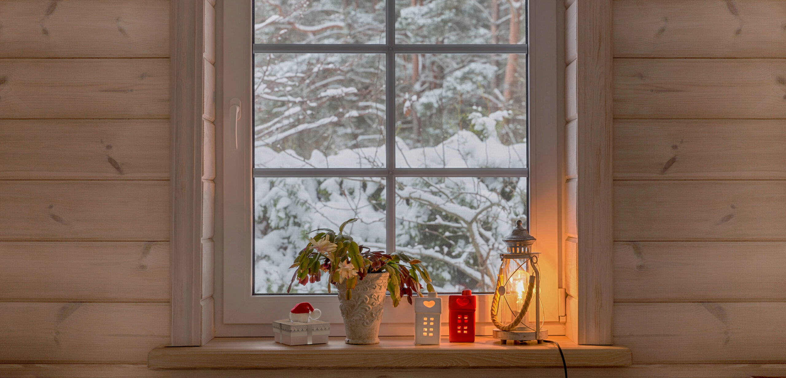Snowy window with lantern in front